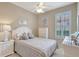 Bright bedroom features neutral walls, window with shutters, ceiling fan, and coastal-themed décor for relaxation at 13108 Torresina Ter, Bradenton, FL 34211