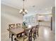 Open-concept dining area showcasing chandelier lighting and a seamless flow to the kitchen at 13108 Torresina Ter, Bradenton, FL 34211