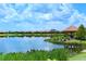 Scenic pond view with lush greenery and neighborhood houses in the background on a clear day at 13108 Torresina Ter, Bradenton, FL 34211