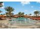 A resort-style pool with fountains, lounge chairs, umbrellas, and tropical landscaping for relaxation at 13108 Torresina Ter, Bradenton, FL 34211