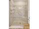 Modern tiled shower with glass door, bench, and grab bars for accessibility in a well-lit bathroom at 13108 Torresina Ter, Bradenton, FL 34211