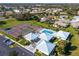 Aerial view of tennis courts, a pool and the community clubhouse with ample parking at 1654 Waxwing Ct, Venice, FL 34293