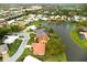 Aerial view of the home nestled alongside a serene lake, showcasing its beautiful landscaping at 1654 Waxwing Ct, Venice, FL 34293