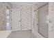 Full bathroom showcasing a shower and tub combo with bright tile and a door to the hallway at 1654 Waxwing Ct, Venice, FL 34293