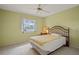Bright bedroom featuring a ceiling fan, neutral carpet, and a window view of the lovely waterfront at 1654 Waxwing Ct, Venice, FL 34293