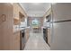 Galley kitchen with light cabinetry, white appliances, and a breakfast nook at 1654 Waxwing Ct, Venice, FL 34293