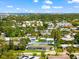 Aerial view of a home with a yellow driveway in a lush, green neighborhood with tall buildings in the distance at 1723 Laramie St, Sarasota, FL 34231