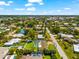 Aerial view of single-story home featuring a screened-in pool, lush landscaping, and a beautiful residential neighborhood at 1723 Laramie St, Sarasota, FL 34231
