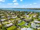 A one-story home with a screened-in pool is displayed in a vibrant, waterfront residential neighborhood from above at 1723 Laramie St, Sarasota, FL 34231