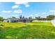 Green backyard with white fence and screened in pool are perfect for outdoor living and entertaining at 1723 Laramie St, Sarasota, FL 34231