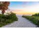Sandy path leading to the beach with lush greenery and a beautiful sunset sky at 1723 Laramie St, Sarasota, FL 34231
