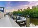 Two boats are docked in a canal at sunset, with lush green trees in the background at 1723 Laramie St, Sarasota, FL 34231