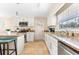 Cozy kitchen featuring granite counters, white cabinets, and a breakfast bar with seating at 1723 Laramie St, Sarasota, FL 34231