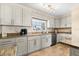 Charming kitchen featuring granite counters, light gray cabinets, and a stainless steel dishwasher at 1723 Laramie St, Sarasota, FL 34231
