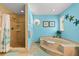 Main bathroom featuring large soaking tub and a separate shower with turquoise colored walls at 1723 Laramie St, Sarasota, FL 34231
