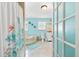 Bright turquoise bathroom featuring a walk-in shower and a soaking tub with jets at 1723 Laramie St, Sarasota, FL 34231
