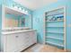Turquoise bathroom with double vanity, decor, and shelves with storage space at 1723 Laramie St, Sarasota, FL 34231