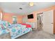 Peach-colored main bedroom with a tv, closet and doorway to an ensuite bathroom at 1723 Laramie St, Sarasota, FL 34231