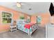 Bright main bedroom featuring peach-colored walls, a ceiling fan, and a doorway to the bathroom at 1723 Laramie St, Sarasota, FL 34231