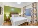 Stylish bedroom with green accent wall, a decorative headboard, and floral print curtains at 2124 N Tamiami Trl # 108, Sarasota, FL 34234