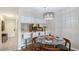 Bright dining area with modern chandelier, table settings, and a view of the kitchen, creating a cozy ambiance at 2124 N Tamiami Trl # 108, Sarasota, FL 34234