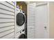 Convenient laundry closet featuring a stacked washer and dryer unit and a hot water tank at 2124 N Tamiami Trl # 108, Sarasota, FL 34234