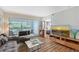 Comfortable living area with a view to a bedroom, sliding glass doors to balcony, and modern entertainment center at 2124 N Tamiami Trl # 108, Sarasota, FL 34234