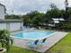 Community pool with lounge chairs near a canal at 2124 N Tamiami Trl # 108, Sarasota, FL 34234