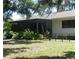 Lush backyard showcasing a screened patio area, mature ferns, and verdant lawn for outdoor enjoyment at 2475 Wood Oak Dr, Sarasota, FL 34232