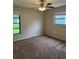 Bedroom with carpet, ceiling fan, and two windows providing natural light to the space at 2475 Wood Oak Dr, Sarasota, FL 34232