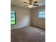 Bedroom with carpet, ceiling fan, and two windows providing natural light to the space at 2475 Wood Oak Dr, Sarasota, FL 34232
