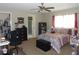 Bright bedroom featuring a ceiling fan, patterned bedding, a large window, and a walk-in closet at 2475 Wood Oak Dr, Sarasota, FL 34232