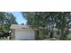 Charming one-story home featuring an attached two-car garage and lush front yard landscaping at 2475 Wood Oak Dr, Sarasota, FL 34232