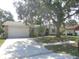 Charming single-story home featuring an attached two-car garage, mature trees and landscaping at 2475 Wood Oak Dr, Sarasota, FL 34232