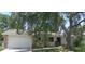 Charming single-story home with attached garage, mature trees, and well-maintained landscaping at 2475 Wood Oak Dr, Sarasota, FL 34232