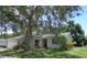 Lovely single-story home featuring a well-manicured lawn and mature trees shading the property at 2475 Wood Oak Dr, Sarasota, FL 34232