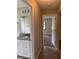 Hallway view of the bathroom with granite countertop and the bedroom with carpet at 2475 Wood Oak Dr, Sarasota, FL 34232