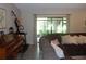 Comfortable living room features large windows and a view, with a piano and treadmill for entertainment and exercise at 2475 Wood Oak Dr, Sarasota, FL 34232
