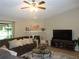 Cozy living room featuring a decorative fireplace, plush sofa, and a large-screen television at 2475 Wood Oak Dr, Sarasota, FL 34232