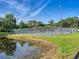 Tennis court with a pond in the background and natural surroundings offering a great recreational experience at 2475 Wood Oak Dr, Sarasota, FL 34232