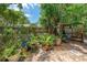 Charming backyard garden with potted plants and a relaxing seating area under a wooden structure at 2630 Bucida Dr, Sarasota, FL 34232