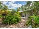 Lush backyard featuring a paved patio, tropical plants, and a serene garden setting at 2630 Bucida Dr, Sarasota, FL 34232