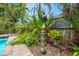 Landscaped backyard oasis with lush greenery, unique decor, and a whimsical bicycle painting on the wooden fence at 2630 Bucida Dr, Sarasota, FL 34232