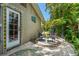 Enjoy this inviting backyard with a comfortable seating area, lush landscaping, pool views and a charming, tiled back door at 2630 Bucida Dr, Sarasota, FL 34232