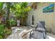 Relaxing backyard with a stainless steel gas grill, comfortable seating area, lush landscaping and a tiled back door entrance at 2630 Bucida Dr, Sarasota, FL 34232