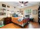 Cozy bedroom with a metal frame bed, wood floors, and bright natural light at 2630 Bucida Dr, Sarasota, FL 34232
