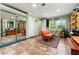 Well-lit bonus room with an orange sofa, a large mirror, and a workspace, perfect for hobbies at 2630 Bucida Dr, Sarasota, FL 34232