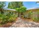 Front exterior view of the home showcasing the home's tropical landscaping and tiled brick walkway at 2630 Bucida Dr, Sarasota, FL 34232