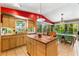 Well-lit kitchen with an island, wooden cabinets, stainless steel appliances, and tile floors at 2630 Bucida Dr, Sarasota, FL 34232