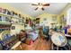 Cozy living room with a ceiling fan, hardwood floors, and an array of shelves with books and decor at 2630 Bucida Dr, Sarasota, FL 34232